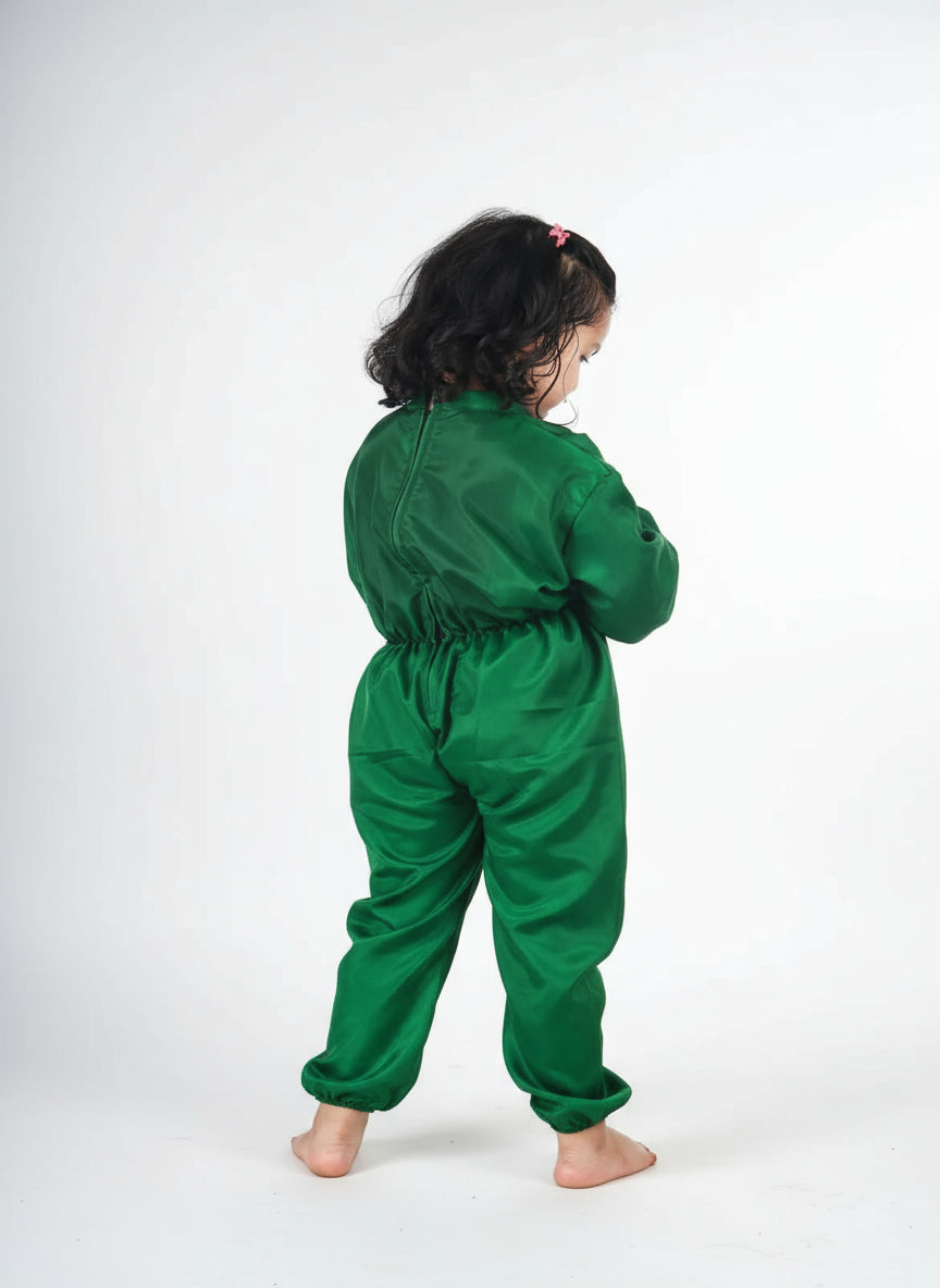 Child wearing a green onesie on a white background