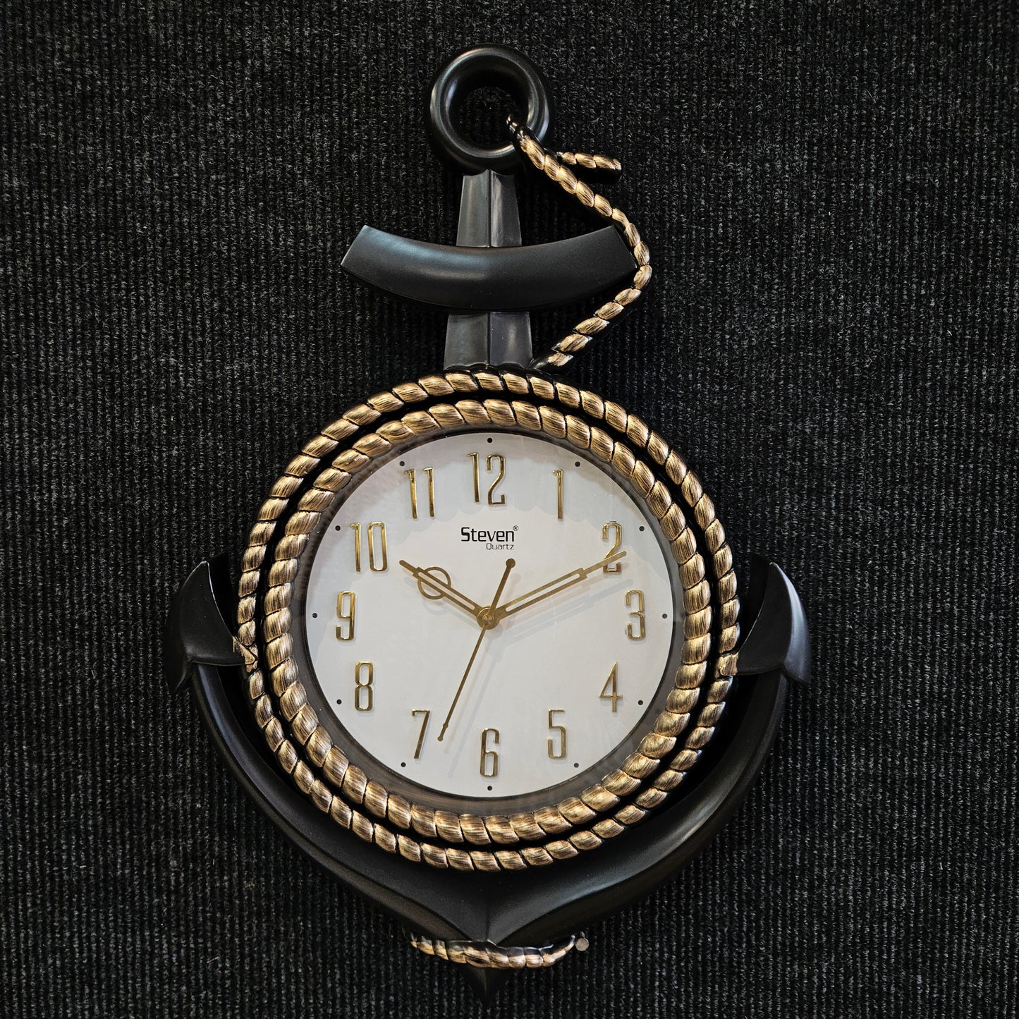 Decorative pocket watch with gold and black design on a dark textured background