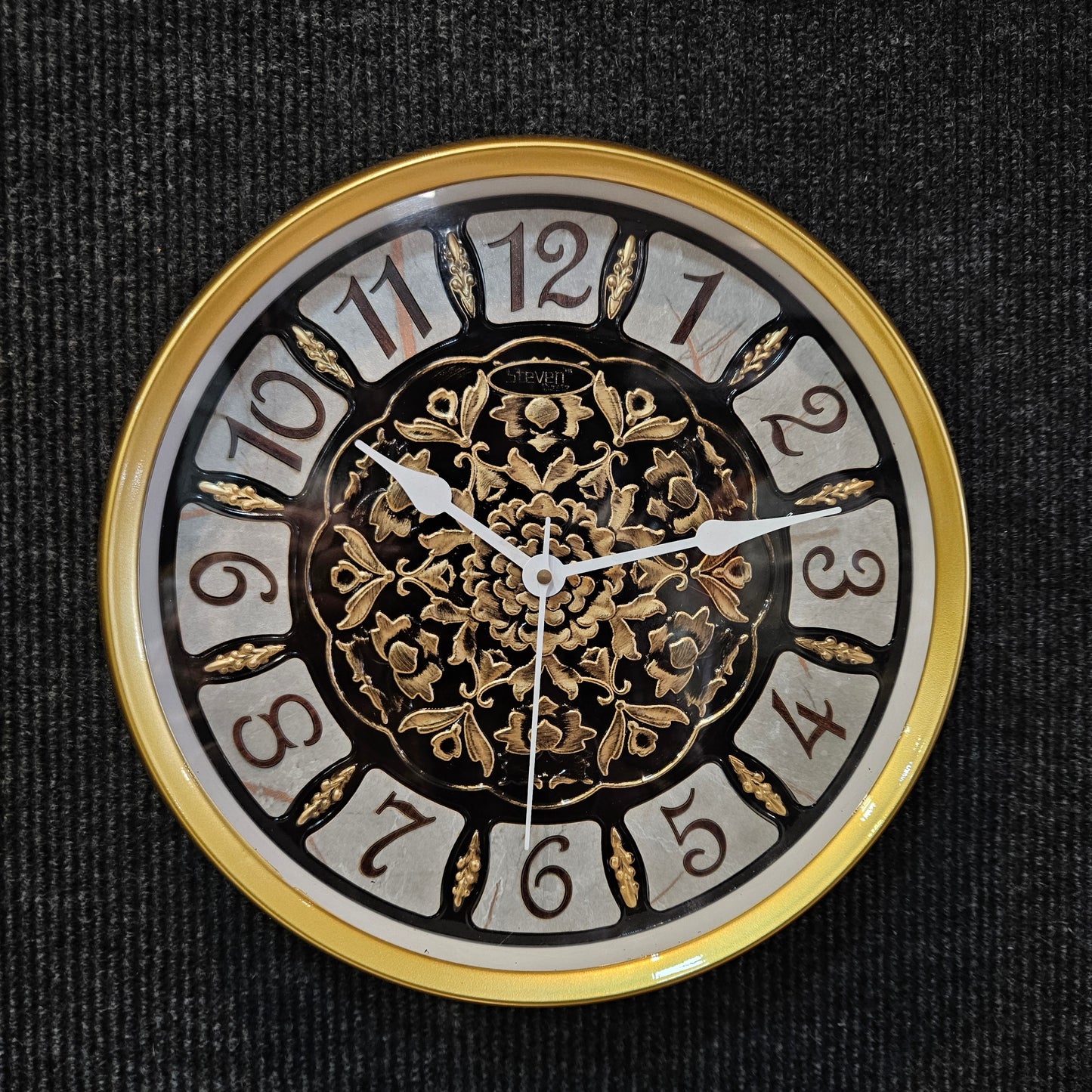 Decorative clock face with gold and black design on a dark background