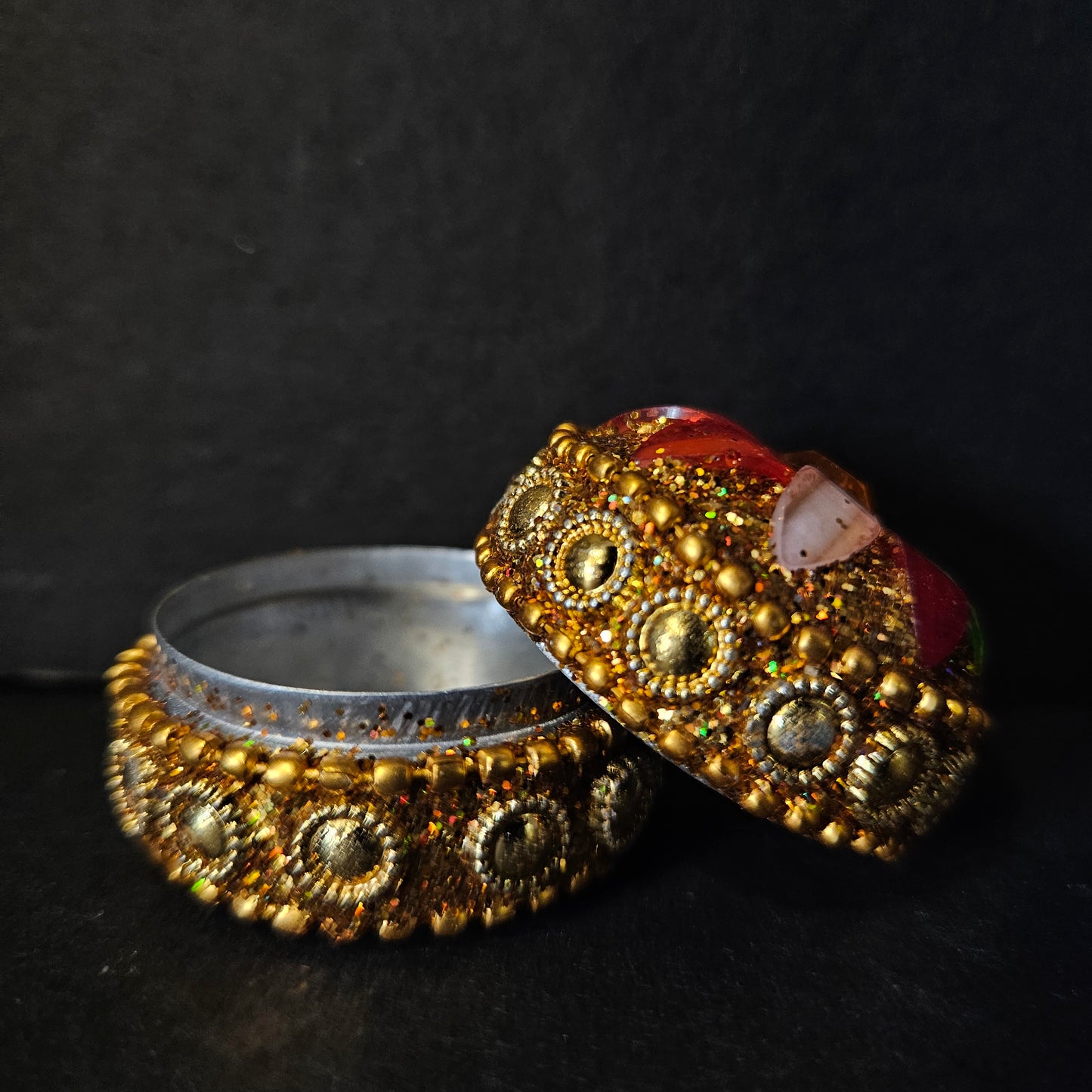 Decorative ring with gold and silver design on a dark background