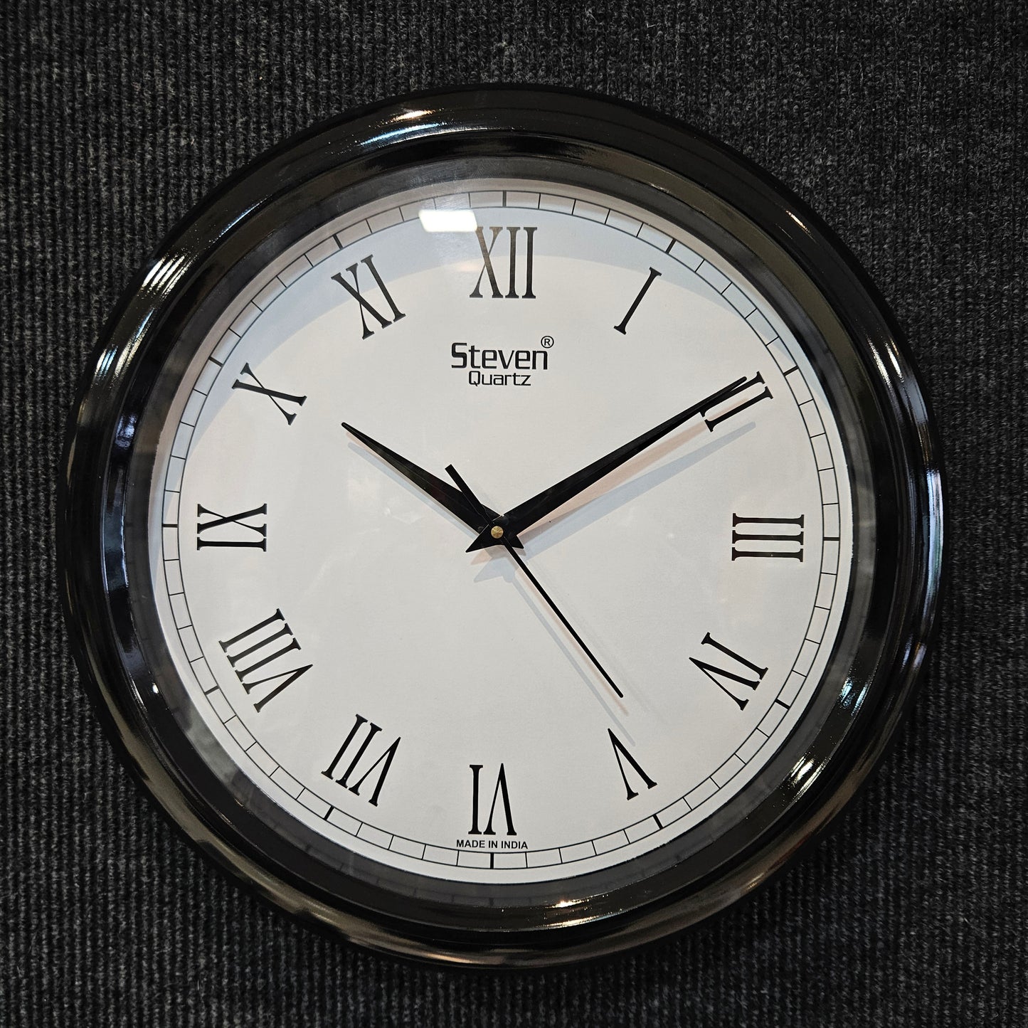 Round wall clock with Roman numerals on a dark textured background