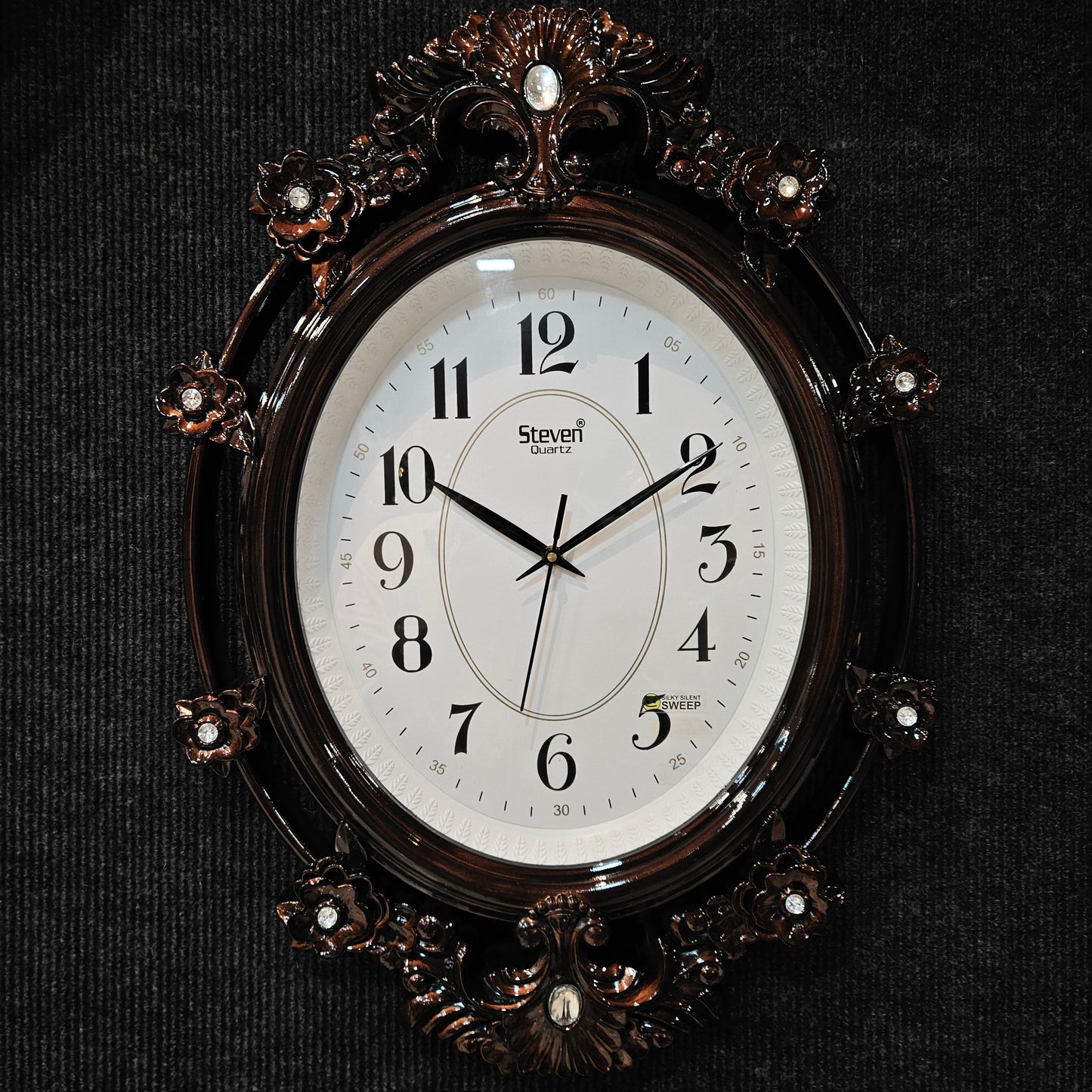 Decorative wall clock with floral designs on a black background