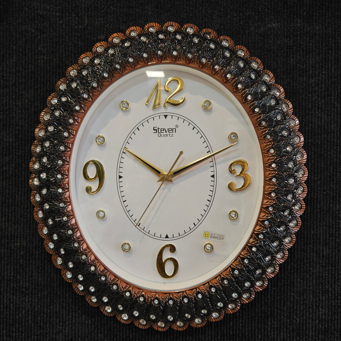 Decorative wall clock with intricate design on a black background