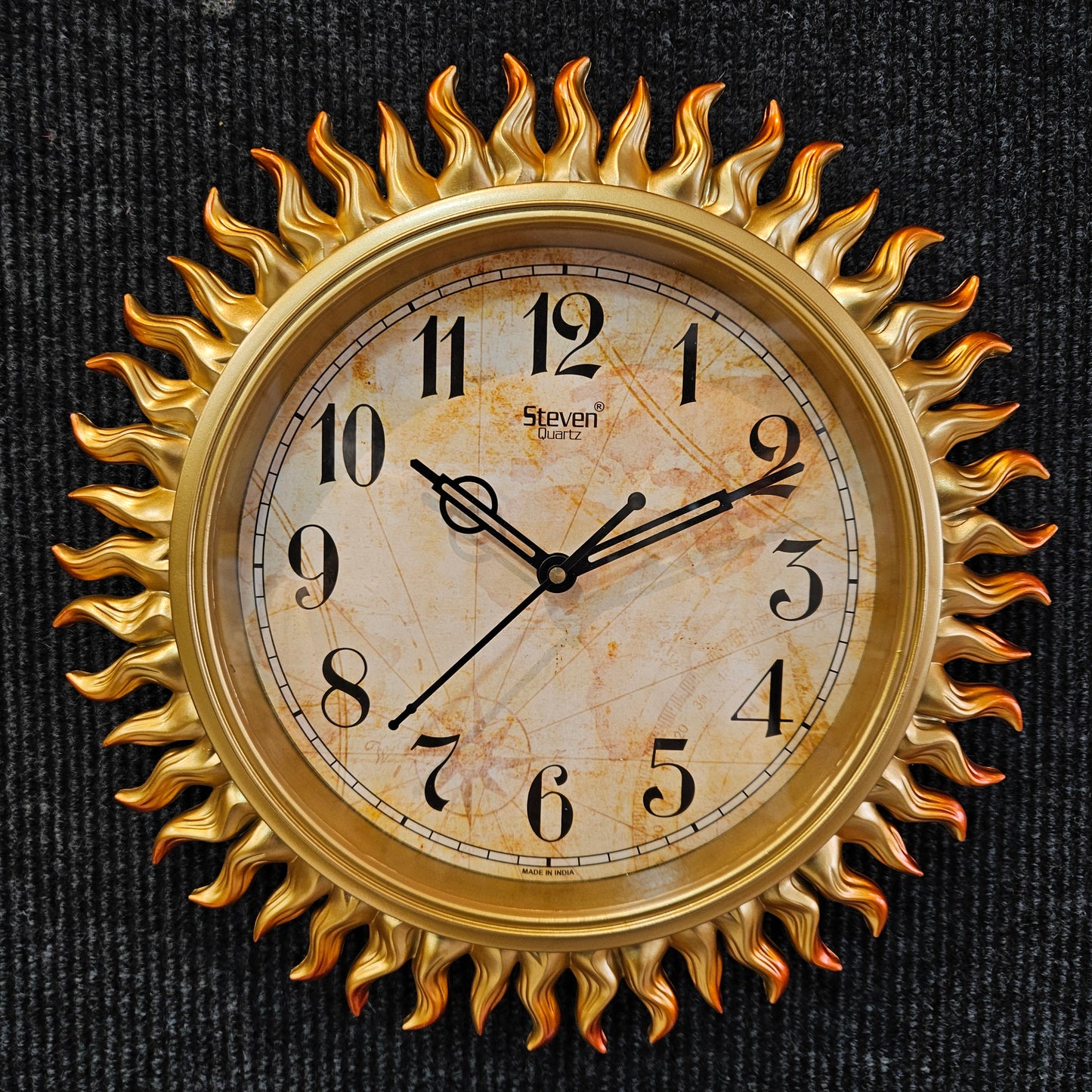 Decorative wall clock with sunburst design on a dark background