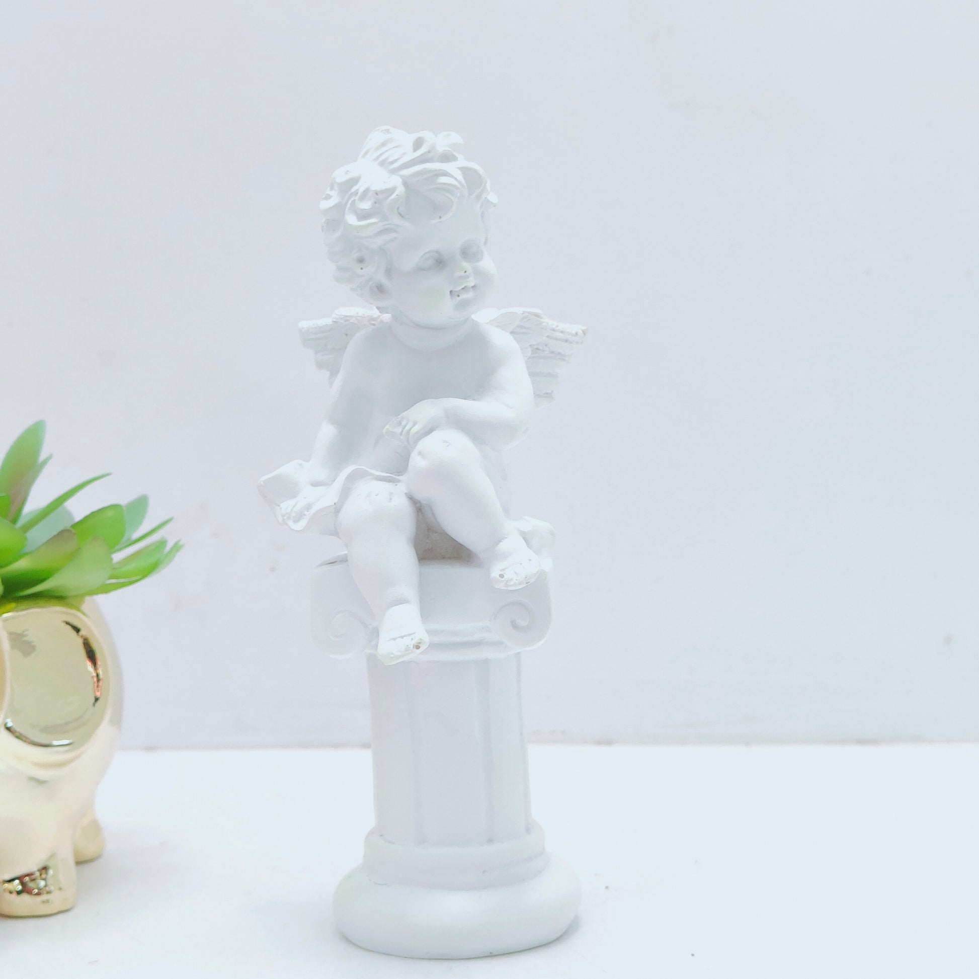 Resin decoration representing an angel on a Pedestal