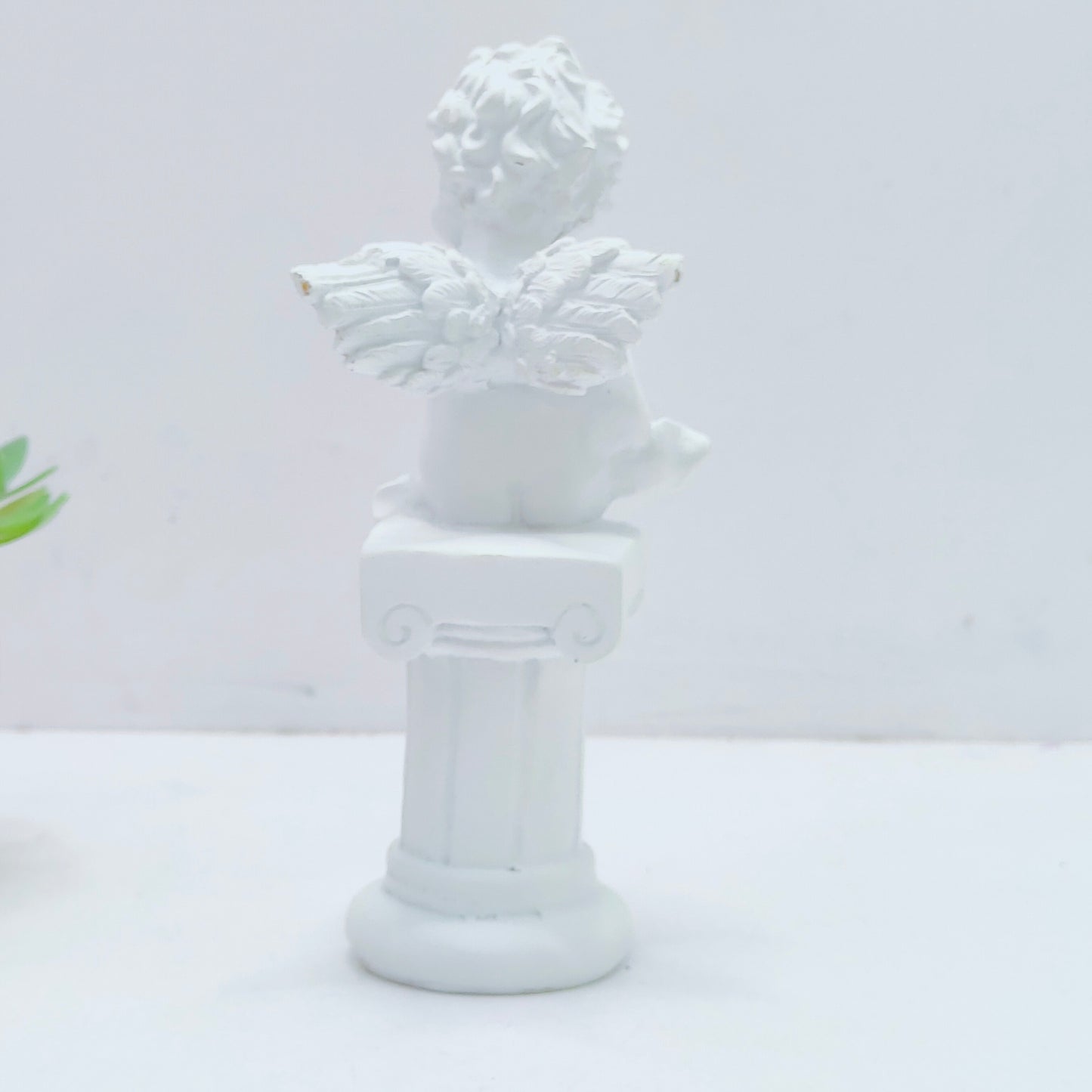 Resin decoration representing an angel on a Pedestal