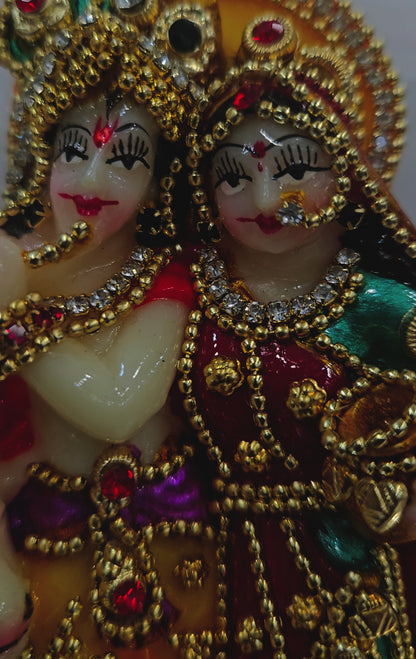 Radha Krishna 24carats gold Plated idol Decorated with attractive stones in a transparent protective cabin