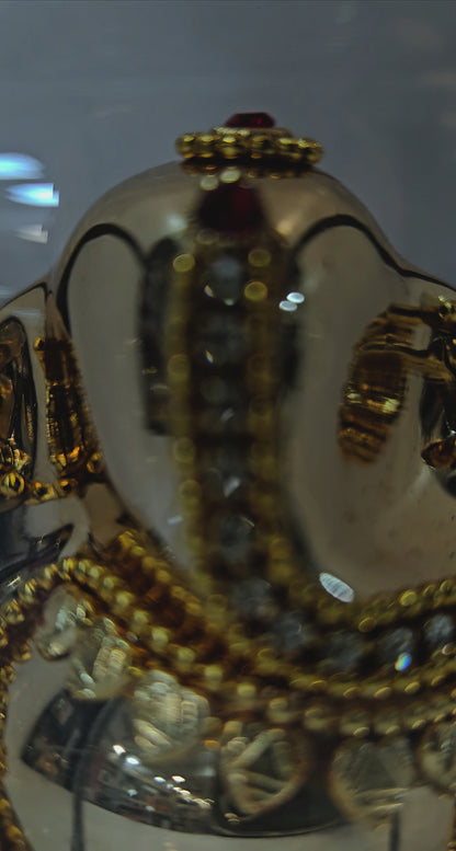 Lord vinayaka murti in a attractive look Decorated with stones designed in a transparent protective cabin