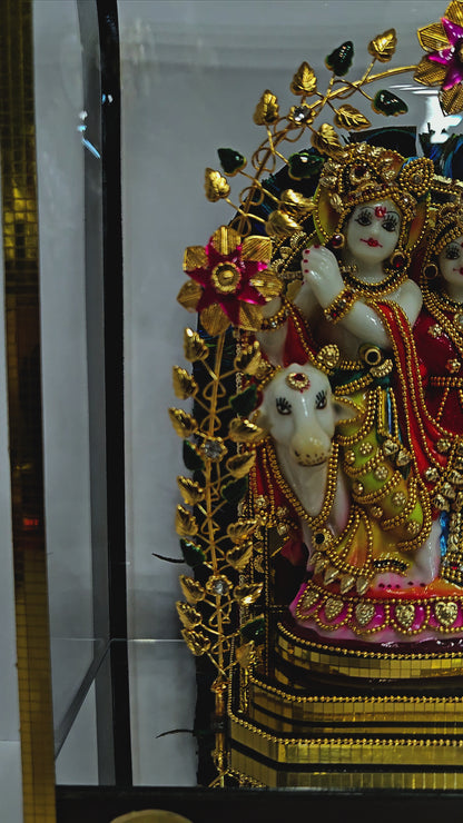 24 carats gold radha Krishna Idol in transparent protective cabin with attractive Leaves&Flowers metal arch,decorative stones designed Statue Showpiece