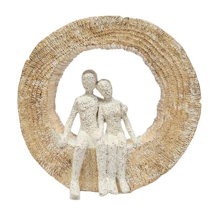 Textured, sand-finish couple figurine seated inside a circular arch, often sold as modern resin home décor