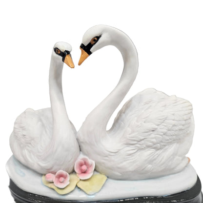 Swan pair showpiece features two white swans forming a heart shape, decorated with pink flowers