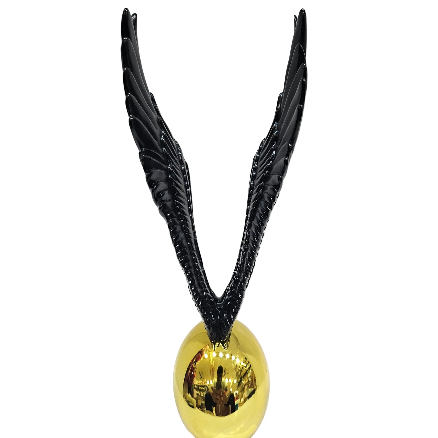 Decorative statue appears to be inspired by the Golden Snitch featuring a gold ball paired with black wings