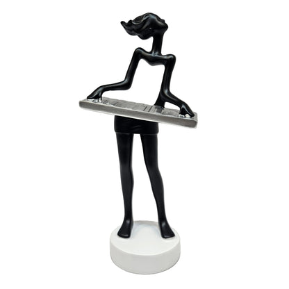 Sleek black modern art lady sculpture of a musician playing a silver keyboard