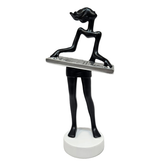 Sleek black modern art lady sculpture of a musician playing a silver keyboard