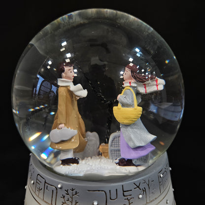 Good looking love Couple in a glass dom with multi colour lighting & with winter snow effect