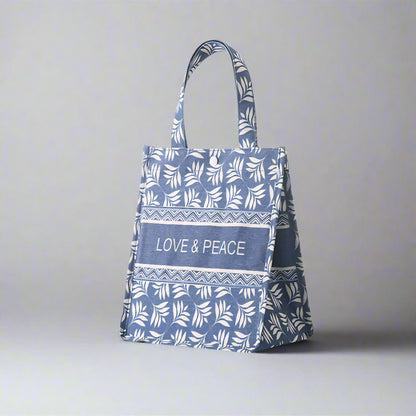 Blue tote bag with white leaf pattern and 'Love & Peace' text on a white background