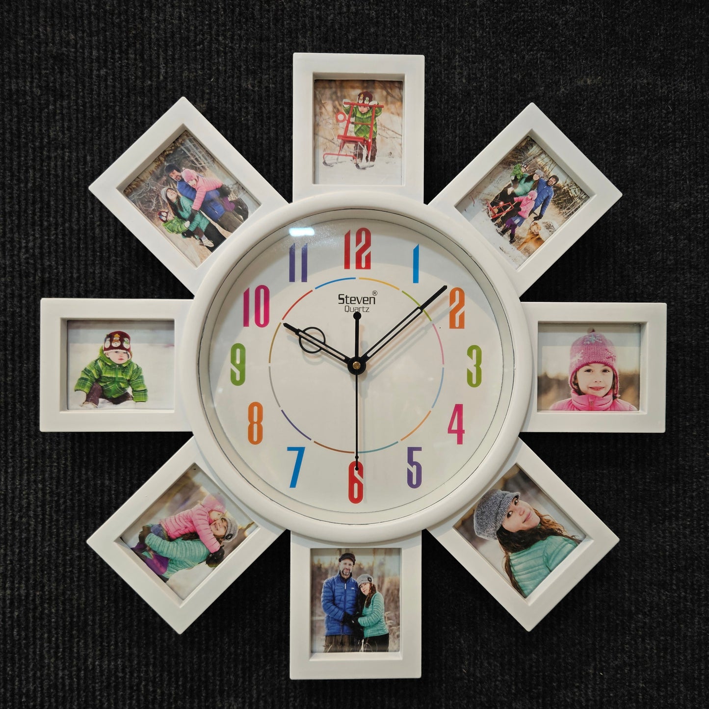Decorative wall clock with multiple photo frames around it on a dark background