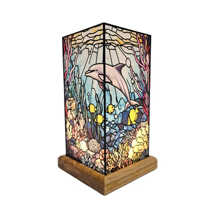 Tiffany-style stained glass dolphin table lamp features a vibrant coral reef scene atop a wooden base