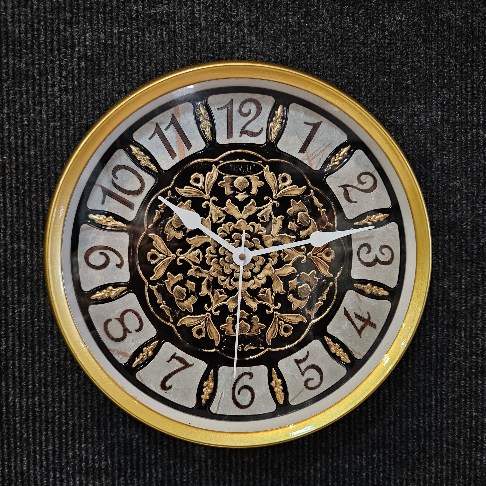 Decorative clock face with gold and black design on a dark background