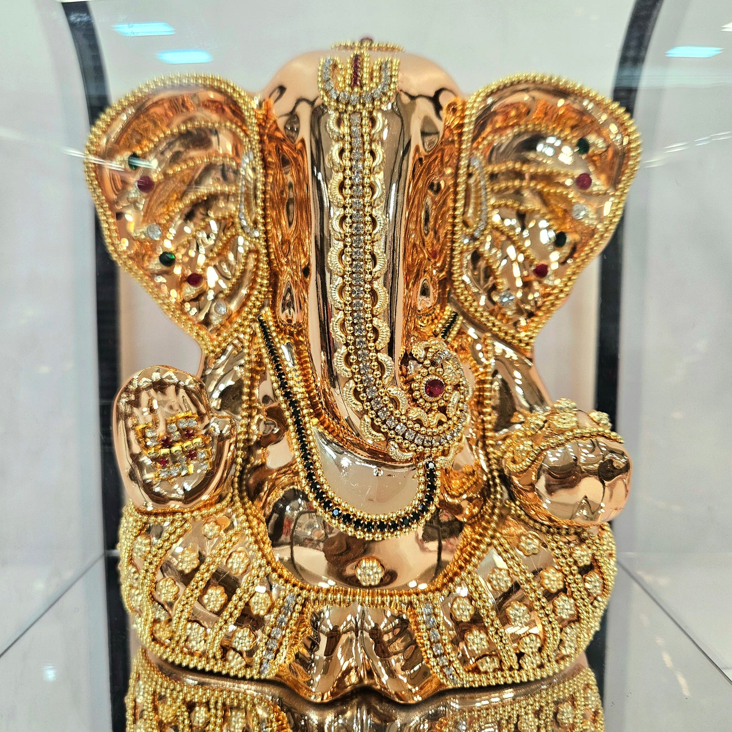 Lord Vinayaka murti 24carats gold Plated idol with attractive stones designed Statue in a transparent protective cabin