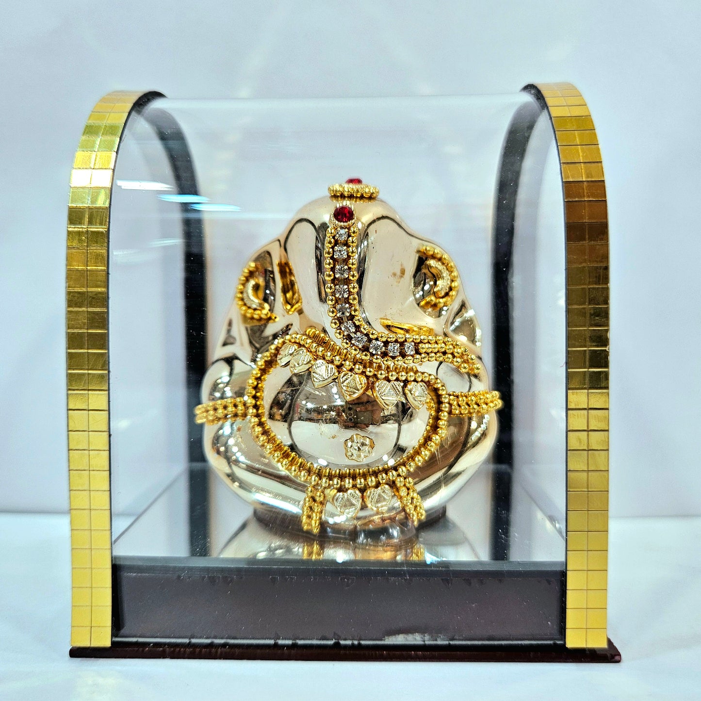 Lord vinayaka murti in a attractive look Decorated with stones designed in a transparent protective cabin