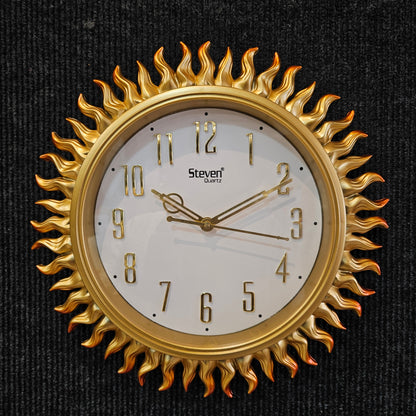 Gold sun-shaped wall clock on a black background