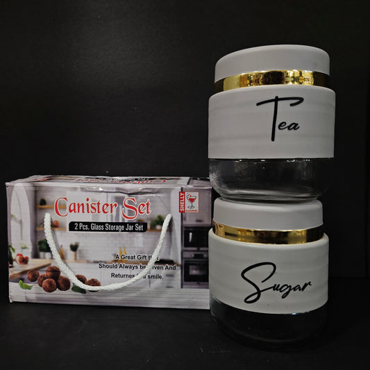 Two glass canisters labeled 'Tea' and 'Sugar' on top of a canister set packaging.
