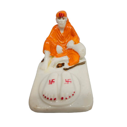 Shirdi Sai Baba statue made of marble, sitting on a base adorned with symbolic footprints.