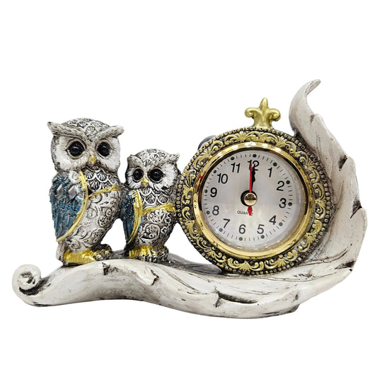 Decorative table clock features a pair of owls sitting on a leaf base, commonly sold as a resin or polyresin figurine
