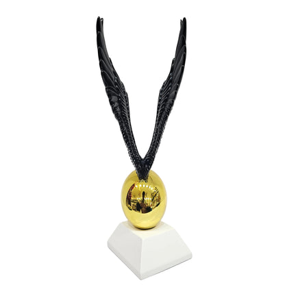 Decorative statue appears to be inspired by the Golden Snitch featuring a gold ball paired with black wings
