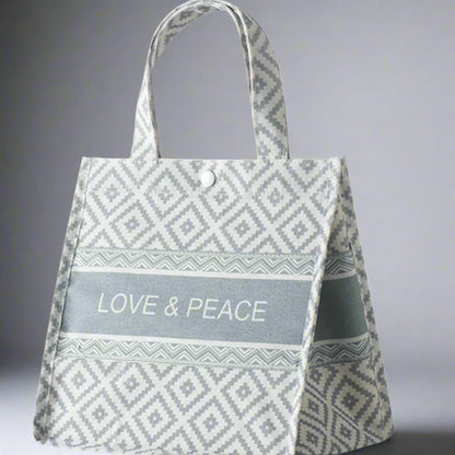 Tote bag with 'Love & Peace' text and geometric pattern on a white background