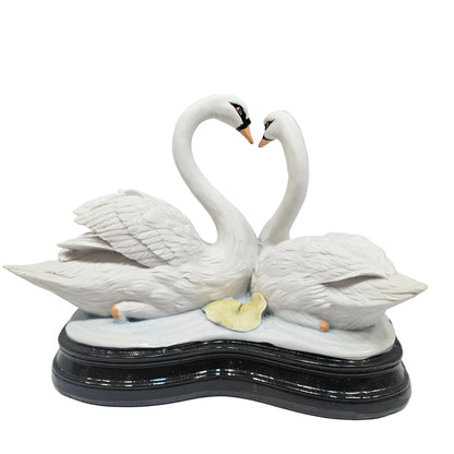 Swan pair showpiece features two white swans forming a heart shape, decorated with pink flowers