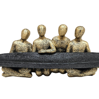 The ExclusiveLane 'Rock Fellowship' showpiece features four gold textured figures surrounding a matte black
tray