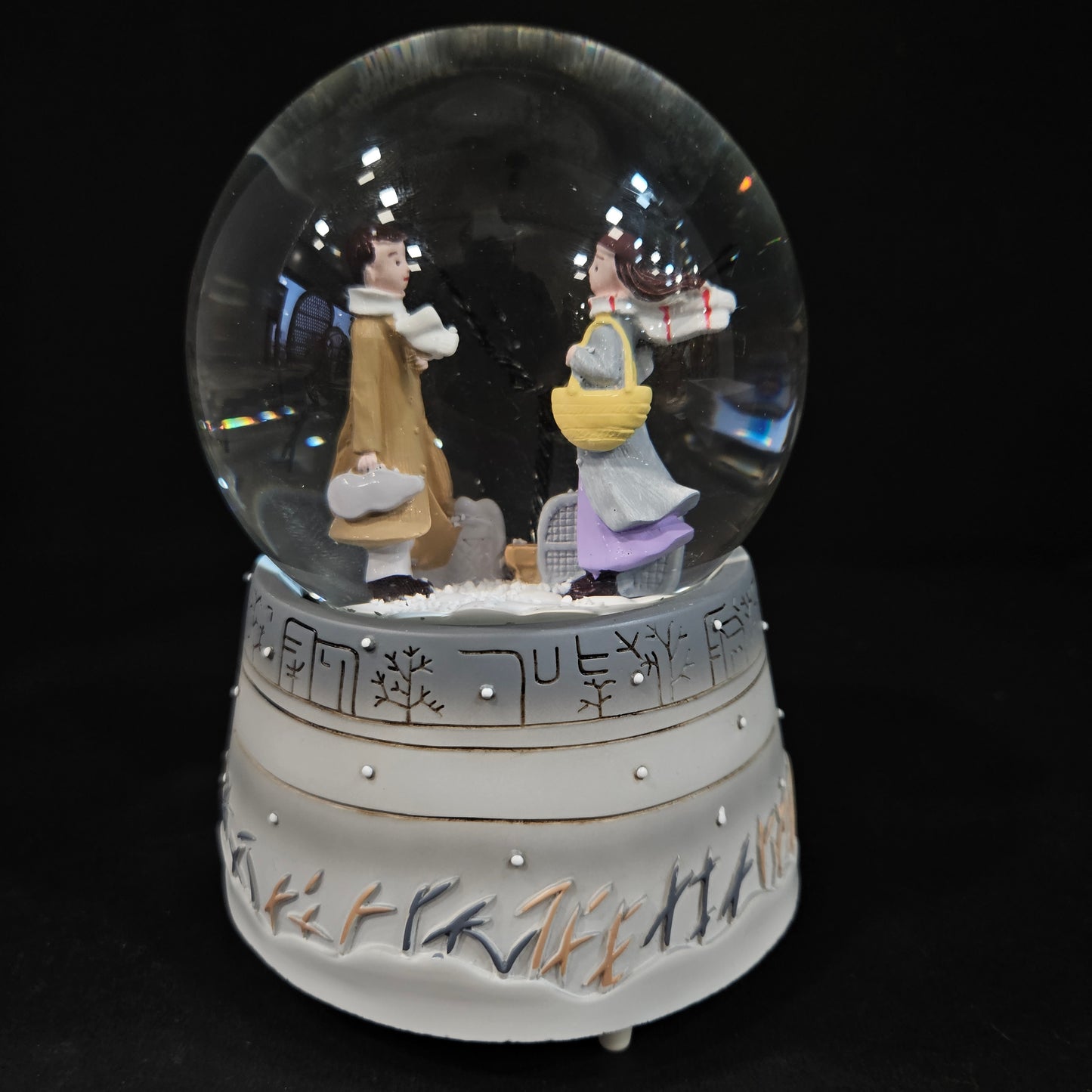 Good looking love Couple in a glass dom with multi colour lighting & with winter snow effect