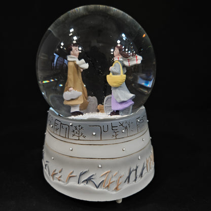 Good looking love Couple in a glass dom with multi colour lighting & with winter snow effect