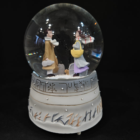 Good looking love Couple in a glass dom with multi colour lighting & with winter snow effect