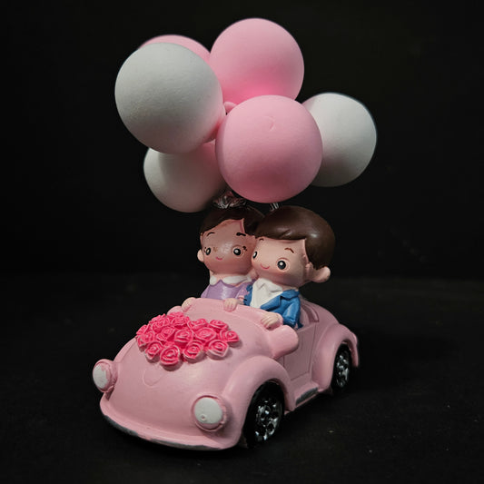 Pink toy car with balloons on a black background