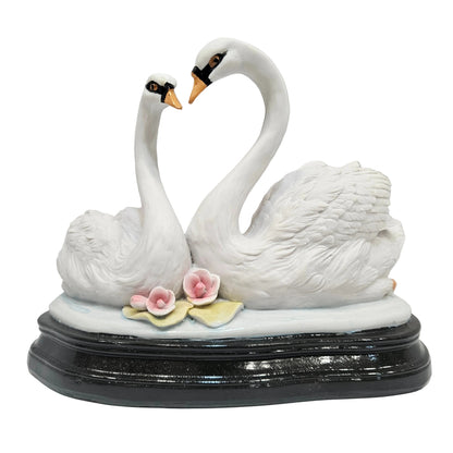 Swan pair showpiece features two white swans forming a heart shape, decorated with pink flowers