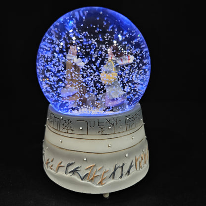Good looking love Couple in a glass dom with multi colour lighting & with winter snow effect