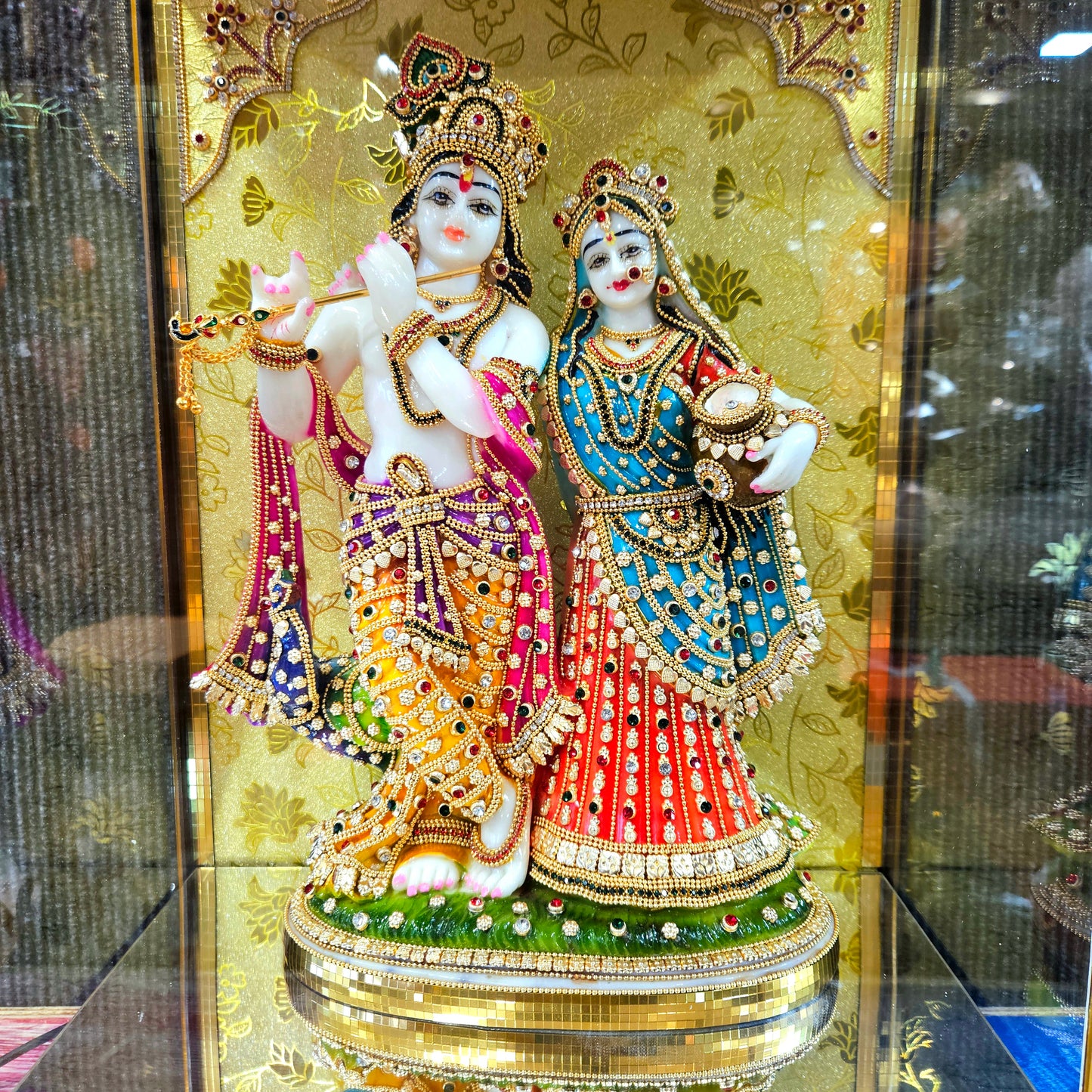 24 carats gold Plated radha Krishna Idol Statue Decorated with attractive stones in a transparent protective cabin with lights