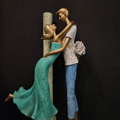 Decorative figurine of a woman lying on a scroll with a flower in her hand against a dark background