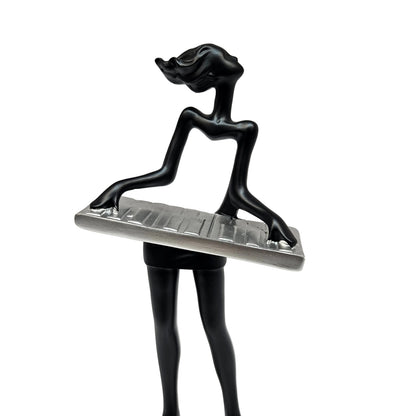 Sleek black modern art lady sculpture of a musician playing a silver keyboard